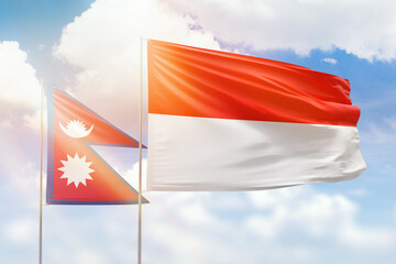 Sunny blue sky and flags of indonesia and nepal