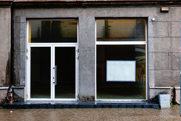 Fototapeta na wymiar Facade of a boutique with a large window and a place for a name. Empty showcase.