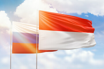 Sunny blue sky and flags of indonesia and russia