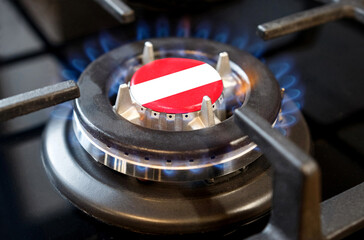 A burning gas burner of a home stove, in the middle of which a flag is depicted - Austria