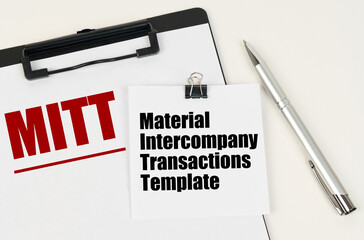On the tablet, a sheet of paper and stickers with the inscription - MITT, Material Intercompany Transactions Template