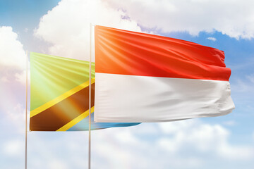Sunny blue sky and flags of indonesia and tanzania