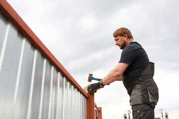 Person repairing fence near house