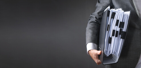 Caucasian businessman holding documents in office.