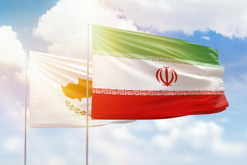 Sunny blue sky and flags of iran and cyprus