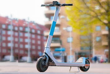 a modern popular form of transport, a rental scooter for moving around the city against the backdrop of a blurred cityscape