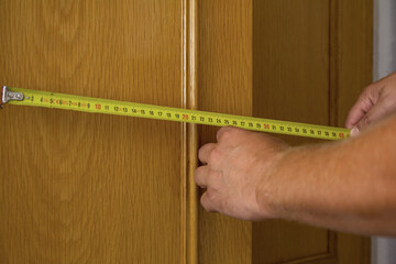 Builder measures the size of an object with a tape measure