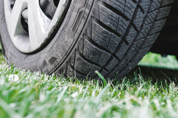 Winter car tire on the green grass