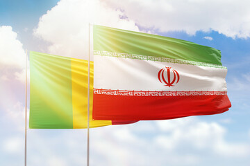 Sunny blue sky and flags of iran and mali