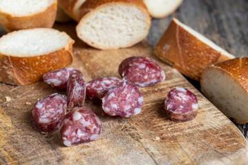 sausage sliced with a baguette on a wooden board