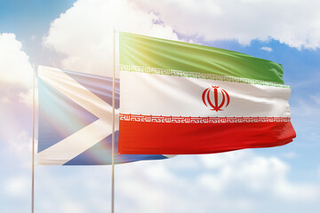 Sunny blue sky and flags of iran and scotland