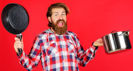 Happy man with frypan and pot. Frying pan. Saucepan. Cooking utensil. Kitchenware. Food preparation.