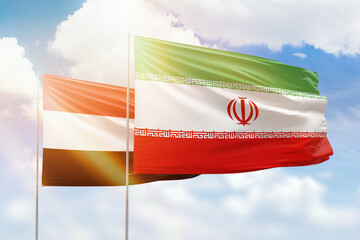Sunny blue sky and flags of iran and yemen