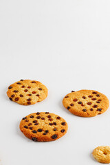 Chocolate american cookies with chocolate chips and raisins on white wooden table. Top view, flat lay.