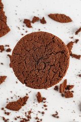 Chocolate american cookies with chocolate chips and raisins on white wooden table. Top view, flat lay.