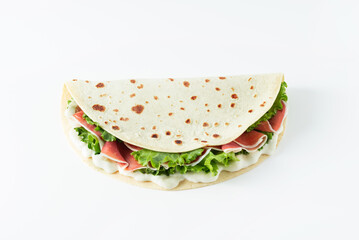 Italian street food flat lay with piadina isolated on a white background.  Piadina romagnola - Italian flatbread with prosciutto, salad and cream cheese