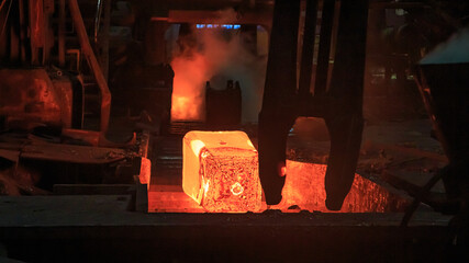 Hot red steel slabs in iron foundry workshop.
