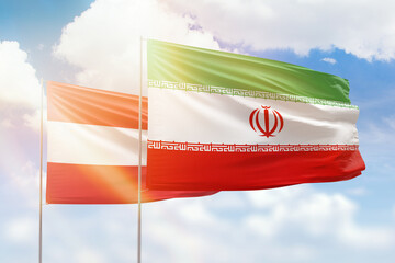 Sunny blue sky and flags of iran and austria