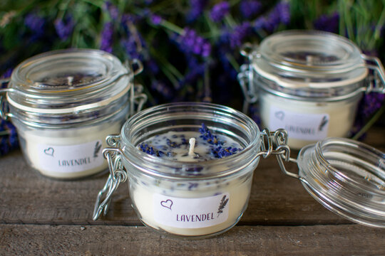 drei Lavendel Duftkerze mit Blüten im Glas mit Bügelverschluss.