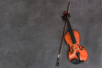 Violin and bow on gray wood background. Flat lay, top view, copy space. Concept of classical music,...