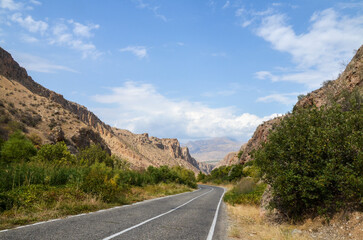 Scenic landscape with an asphalt empty winding road passing through a Caucasian mountain gorge, in Armenia. Travel adventure concept
