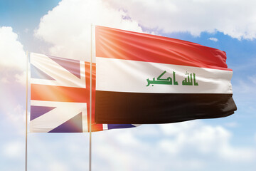 Sunny blue sky and flags of iraq and great britain