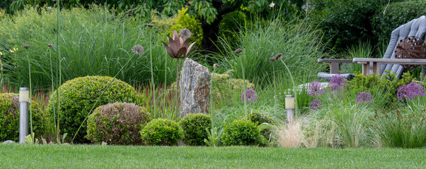 Kamień dekoracyjny w pięknym ogrodzie wśród bukszpanów