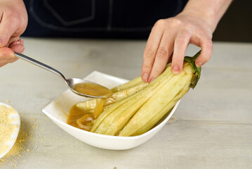 eggplant is poured with a special sauce before being covered with breadcrumbs. close up