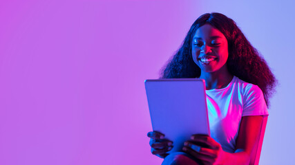 Portrait of joyful young black woman using tablet pc, studying or working remotely, having online...