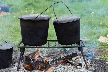 Hiking pot, Bowler in the bonfire. in cauldron at the stake. Traveling, tourism, picnic cooking,...