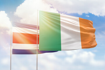 Sunny blue sky and flags of ireland and costa rica