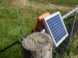 A solar panel powers an electric fence unit on a farm in Canterbury, New Zealand