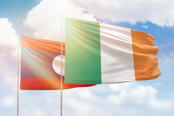 Sunny blue sky and flags of ireland and laos