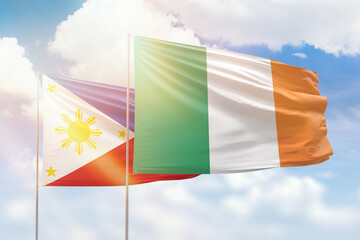 Sunny blue sky and flags of ireland and philippines