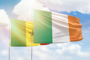 Sunny blue sky and flags of ireland and senegal