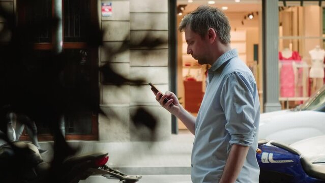 Businessman using smartphone close-up, young man writing message in phone outdoor. Guy chatting with friends online, tourist surfing the internet. 