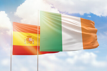 Sunny blue sky and flags of ireland and spain