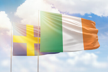 Sunny blue sky and flags of ireland and sweden