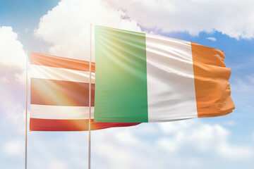 Sunny blue sky and flags of ireland and thailand