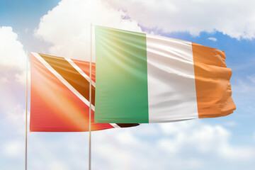 Sunny blue sky and flags of ireland and trinidad and tobago