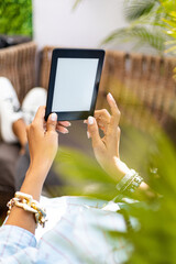 young woman laying down while reading with an e-book