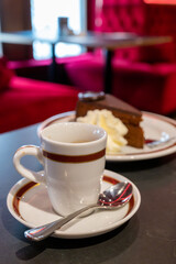 Small cup of black espresso coffee served in traditional cafe in Vienna with red interieur, Austria