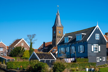 Fototapeta na wymiar Walking on sunny day in small Dutch town Marken with wooden houses located on former island in North Holland, Netherlands