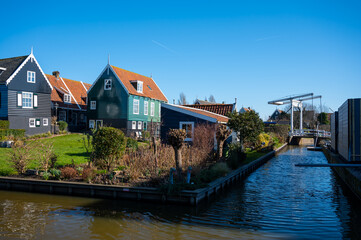 Fototapeta na wymiar Walking on sunny day in small Dutch town Marken with wooden houses located on former island in North Holland, Netherlands