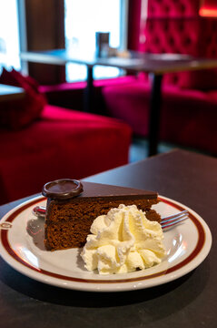 Piece of famous Sachertorte chocolate cake with apricot jam of Austrian origin served in traditional cafe in Vienna