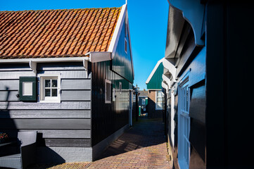 Walking on sunny day in small Dutch town Marken with wooden houses located on former island in North Holland, Netherlands