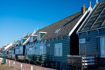 Obraz premium Walking on sunny day in small Dutch town Marken with wooden houses located on former island in North Holland, Netherlands