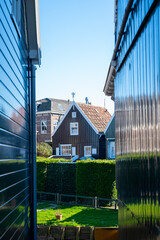 Obraz premium Walking on sunny day in small Dutch town Marken with wooden houses located on former island in North Holland, Netherlands