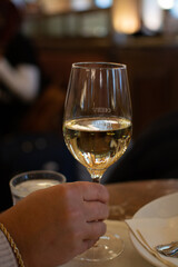 Lifestyle of beautiful Vienna, glass of white dry Austrian wine served in old Viennese-style cafe in Vienna, Austria