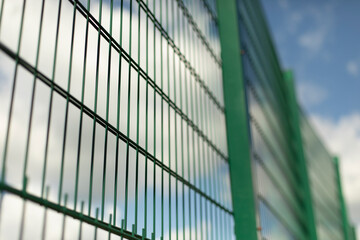 Green fence. Steel mesh on sports field.